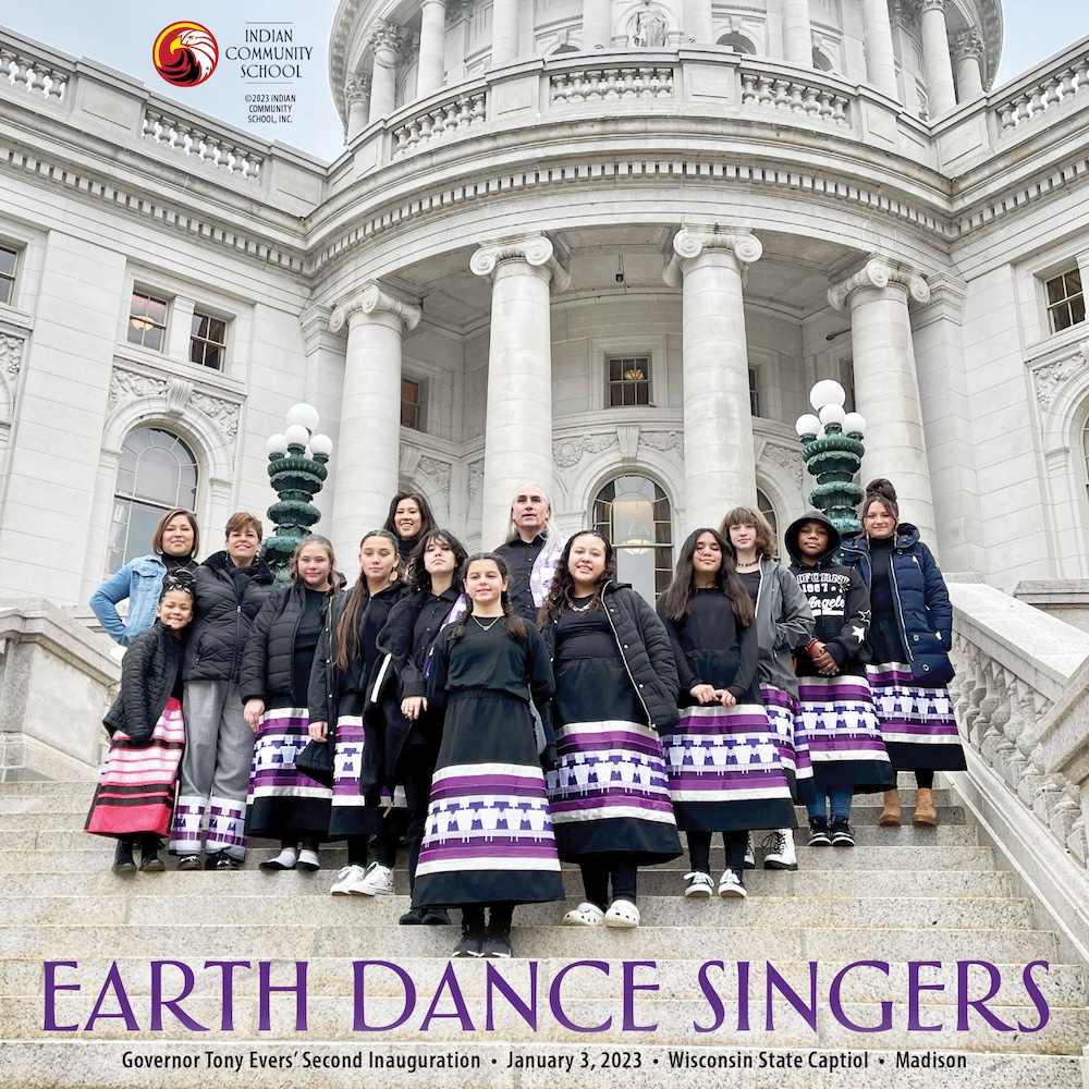 Earth Dance Singers wearing skirts, standing on steps outside of Capital building in Madison, WI.